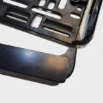 Foto von einer Detailaufnahme der Grundplatte und der Leiste von einem Kennzeichenhalter in schwarz