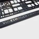 Nahaufnahme eines 3D-Schriftzugs mit glänzender Chromveredelung auf schwarzer Leiste