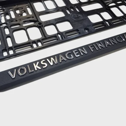 Nahaufnahme eines 3D-Schriftzugs mit glänzender Chromveredelung auf schwarzer Leiste